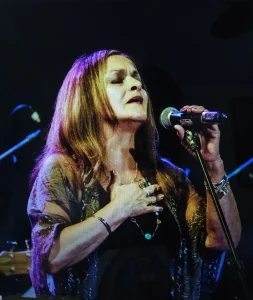 A woman from the band Sister Sister is singing into a microphone.