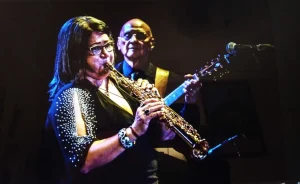 A woman playing soprano saxophone.